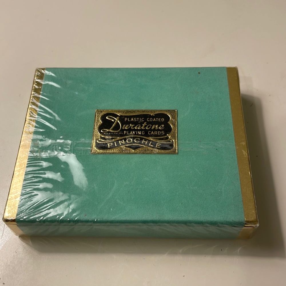 Duratone plastic coated playing cards in floral print in the back.